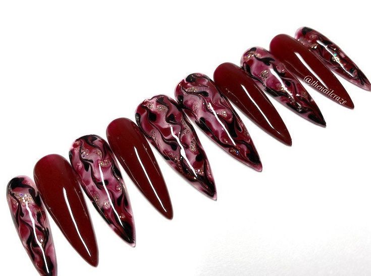 Dramatic Bold Stiletto Nails: Deep Red and Black Swirl Design for Striking Elegance.