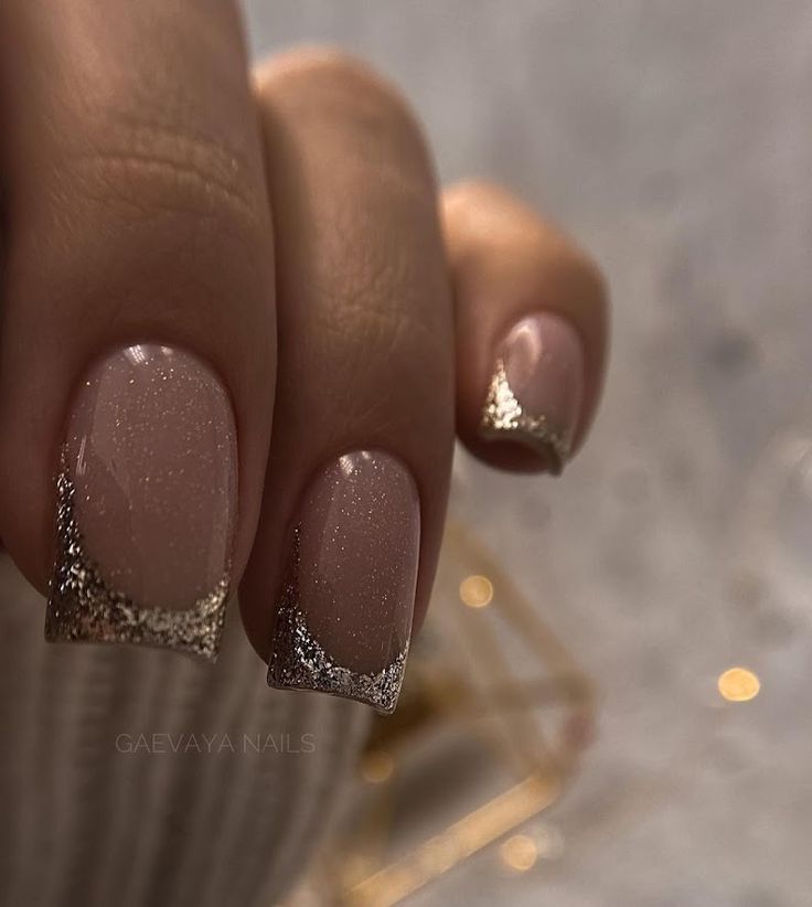 Sophisticated Nude Nails with Sparkling Gold French Tips for Chic Elegance.