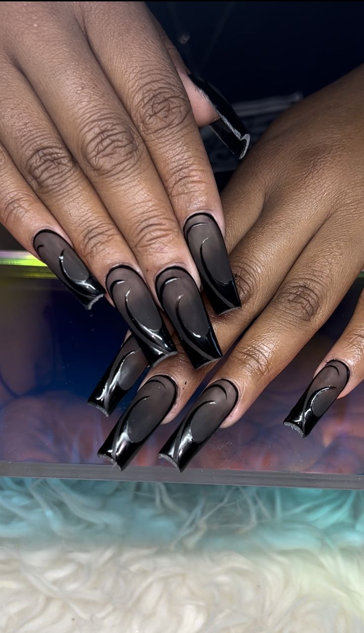 Elegant Black Nail Art with Elongated Tips and Intricate Curved Lines.