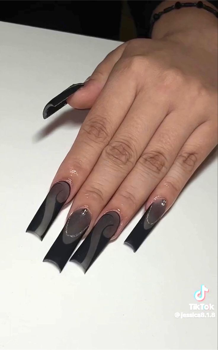 Bold Black Long Nails with Unique Swirls and Elegant Embellishments.