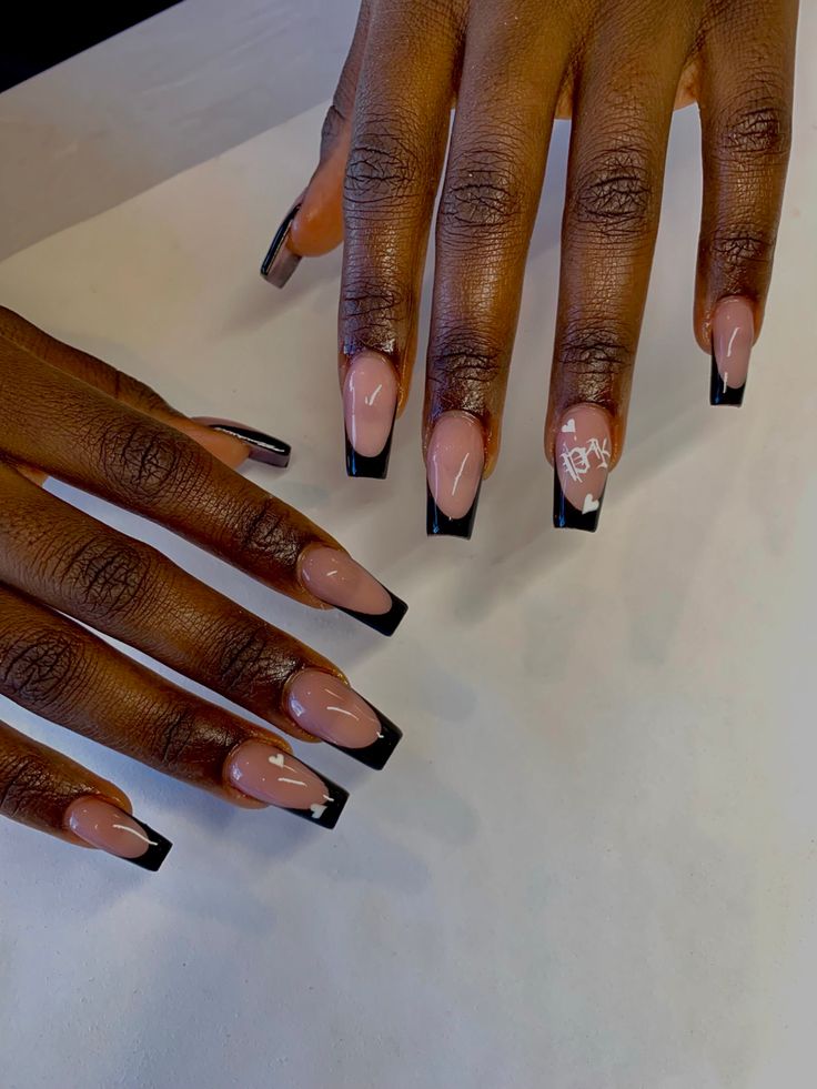 Sophisticated Black and Nude French Tip Nail Design with Intricate Detailing.