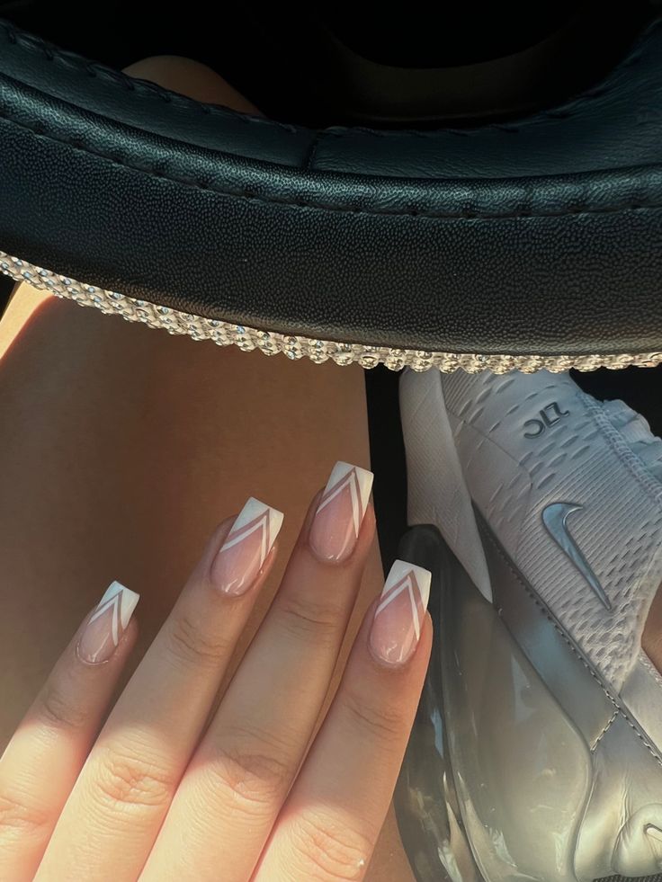 Chic Nail Design: Soft Nudes with Striking White Tips and Geometric Accents.