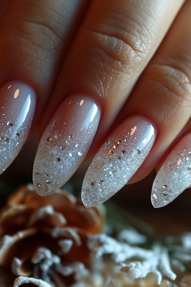 Sophisticated Ombre Nail Design: Translucent Pink to Shimmering Silver Gradient with Sparkles for Festive Elegance.