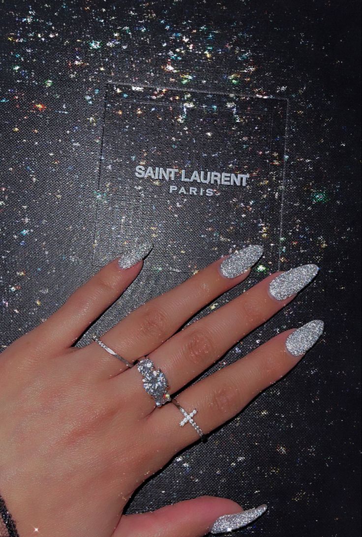 Glamorous Almond-Shaped Nails with Silver Sparkle: A Chic Touch for Special Occasions.