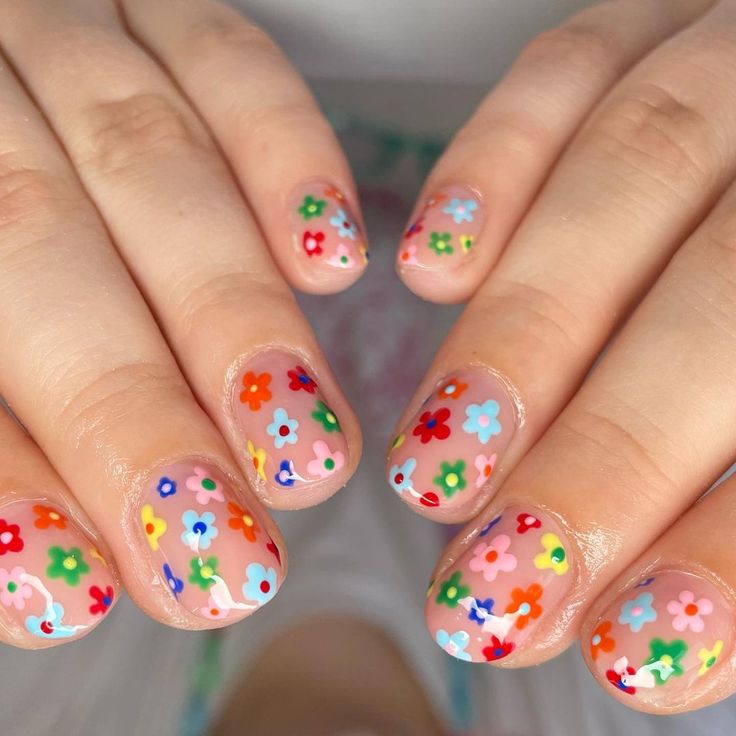 Whimsical Floral Nail Design: Colorful Flowers on Soft Nude for a Cheerful Spring Look