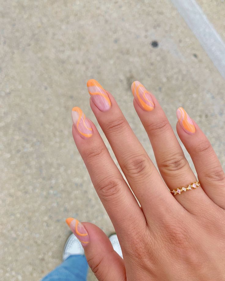 Playful Pink and Orange Swirl Nail Art: A Fresh, Trendy Look with Gold Accents.