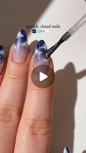 Enchanting Sparkly Cloud Nails: A Dreamy Ombre of Pastels and Deep Blues.