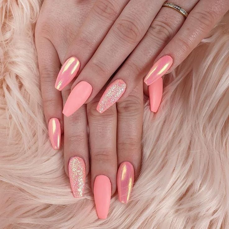 Elegant Chic Coral Pink Nail Design with Shimmering Accents and Glitter Finish.