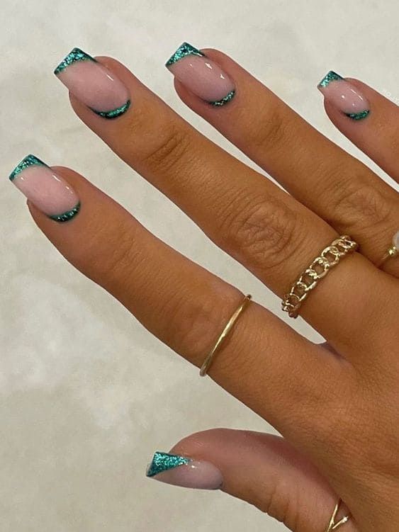 Elegant Glittery French Tips with Teal Accents and Minimalist Gold Rings