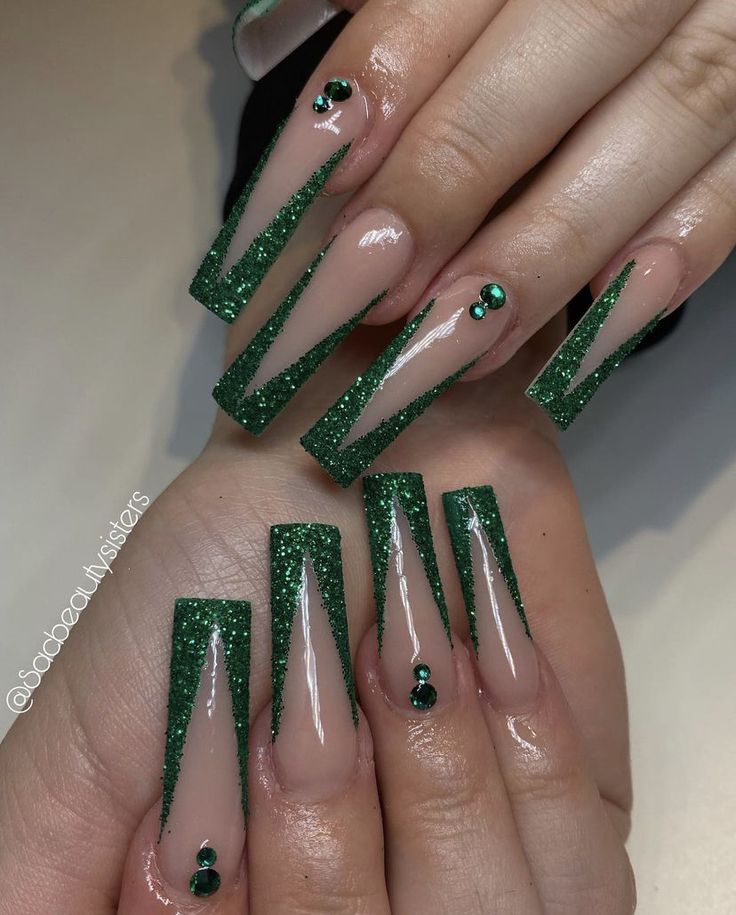 Elegant Green Glitter Nail Design with Bold Triangular Tips and Gem Accents.