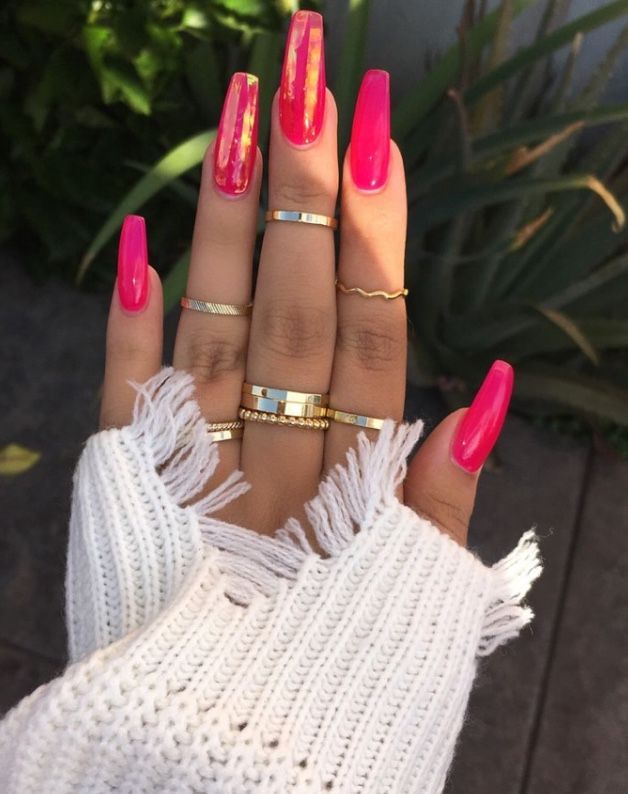 Chic Aesthetic: Bold Pink Almond Nails Paired with Minimalist Gold and Silver Rings