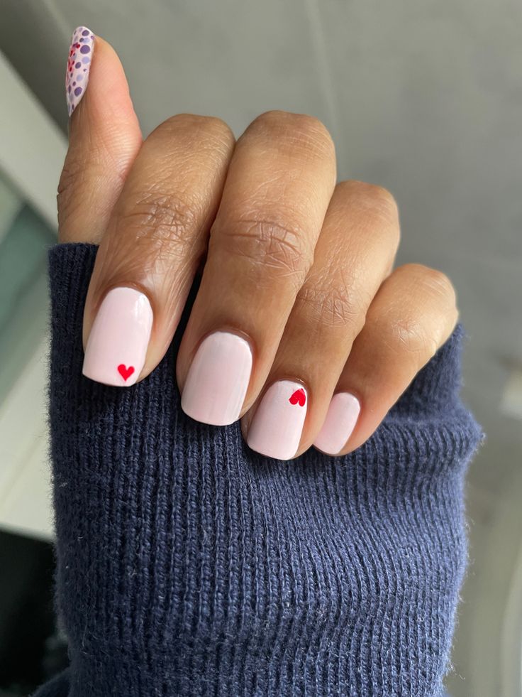 Chic Blush Nails with Minimalist Red Heart Accents for a Romantic Touch.