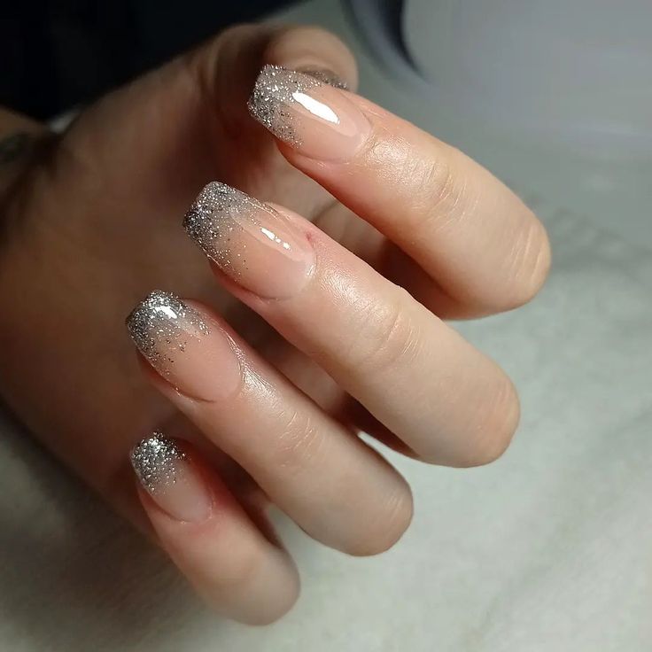 Sophisticated Nude Nail Design with Sparkling Silver Glitter Tips and Elegant Gradient Effect.