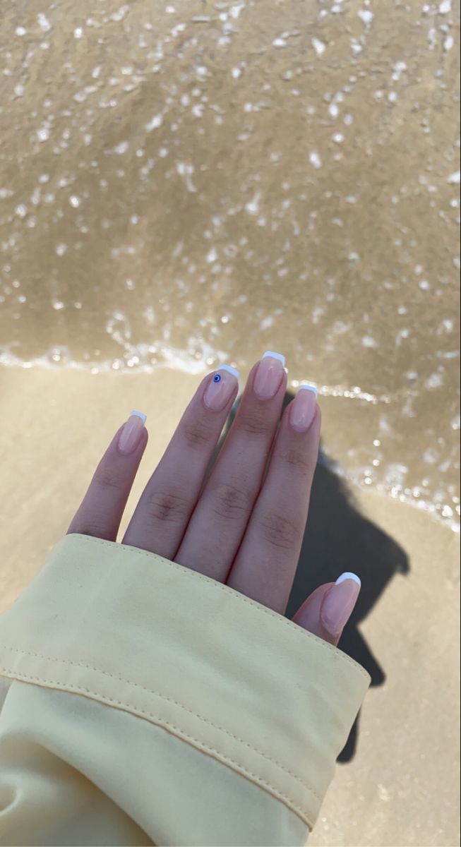 Chic Summer Nails: Soft Nude with French Tips and Playful Blue Accent