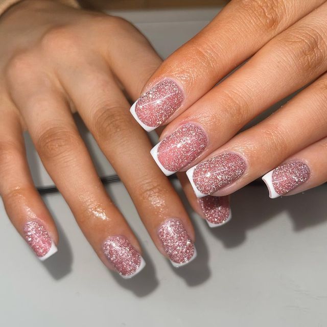 Elegant Glittery Pink Ombre French Tip Nails with a Playful Twist.