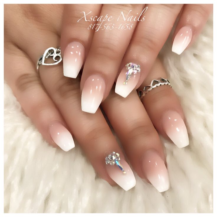 Chic Ombre Nail Design: Nude to White Gradient with Glamorous Rhinestone Accents.