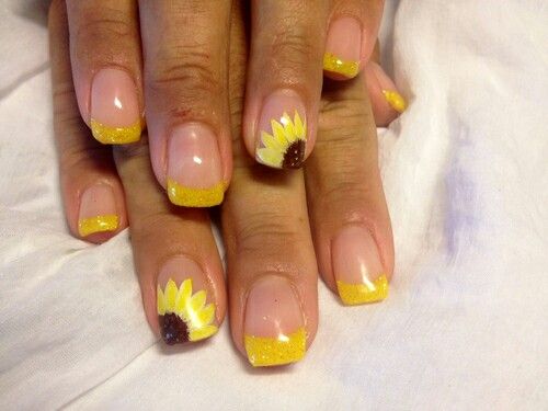 Cheerful Sunflower Nail Design: Glossy Nude Base with Vibrant Yellow Tips and Glitter Accents.