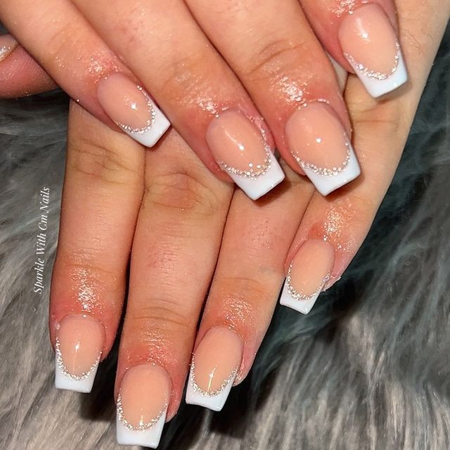 Chic French Tip Manicure with Nude Base, Delicate White Tips, and Rhinestone Accents