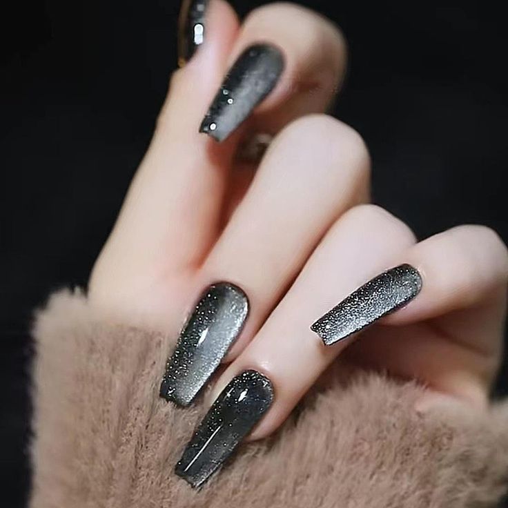 Glamorous Ombre Nail Design in Dark Gray and Black with Sparkling Accents for Elegance.