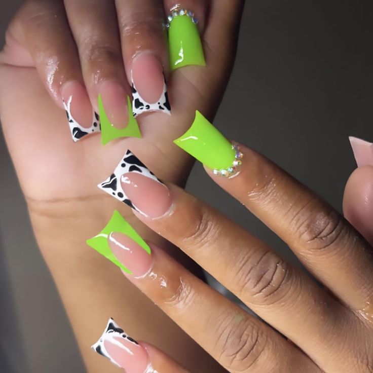 Vibrant Lime Green and Playful Black-and-White Nail Design with Rhinestone Accents.