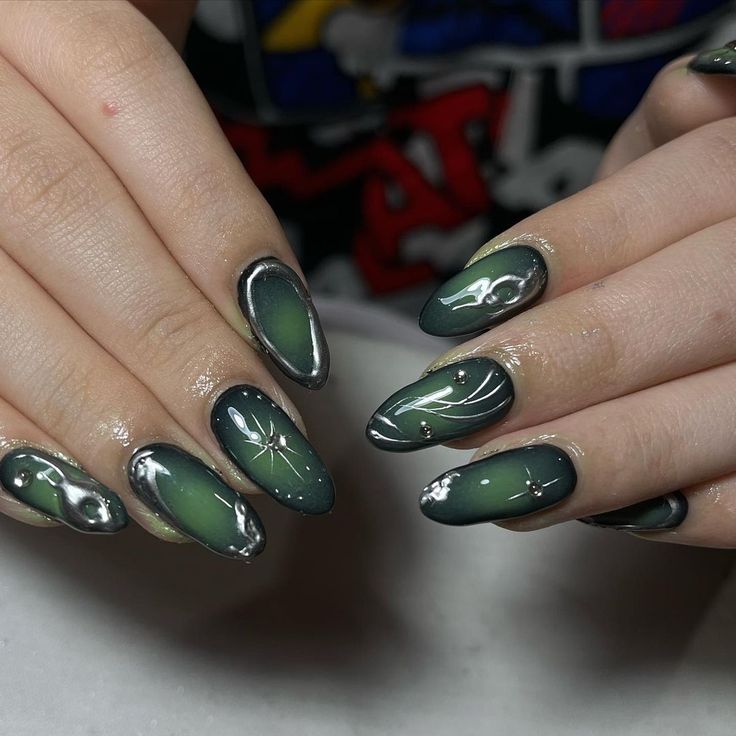 Elegant Almond-Shaped Nail Design in Deep Green and Metallic Silver with Gradient and Leaf Motifs