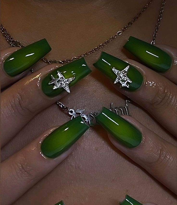 Vibrant Green Ombre Nails with Silver Star Charms: A Chic Blend of Boldness and Elegance.