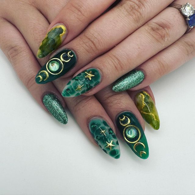 Mystical Celestial Nail Design in Deep Green and Gold with Intricate Moon and Star Embellishments.