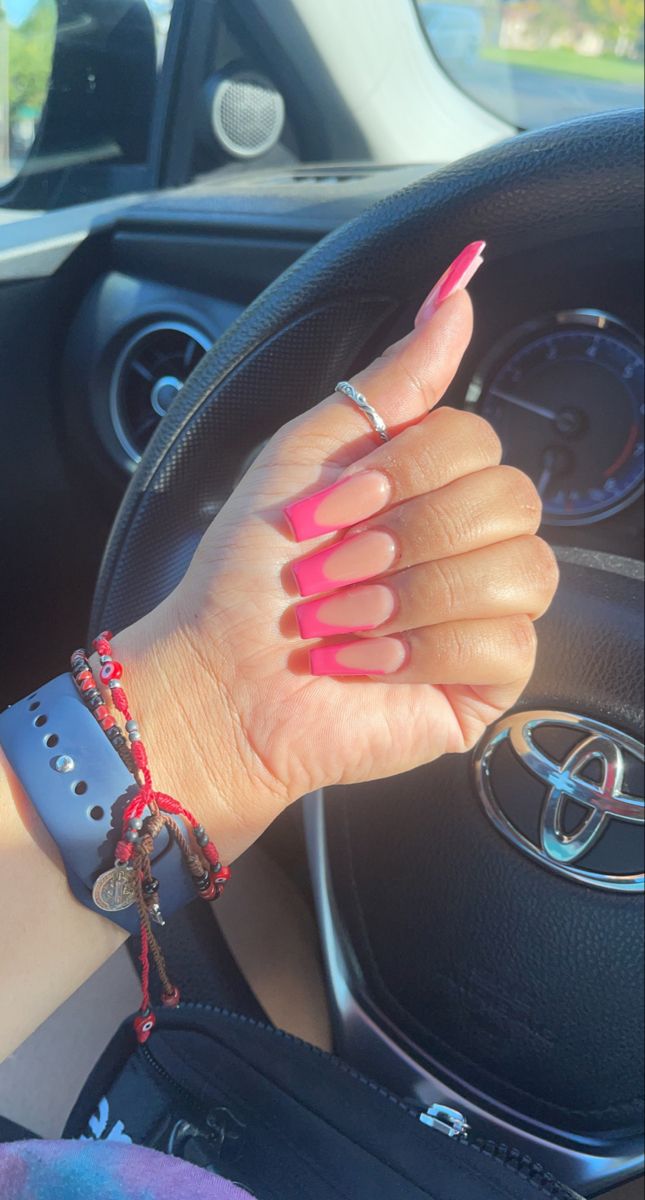 Bold Vibrant Pink Stiletto Nails: A Stylish Statement with Glossy Tips, Matte Base, and Layered Bracelets.