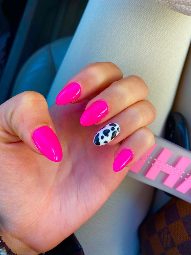 Bold and Playful: Vibrant Pink Nails with Trendy Cow Print Accent.