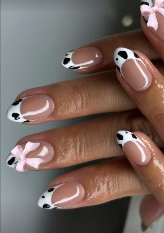 Playful Cow Print Nail Design with Soft Pink Accents and Charming Bow.