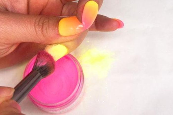 Vibrant Gradient Nail Design with Warm Hues and Playful Colorful Powder Enhancements.