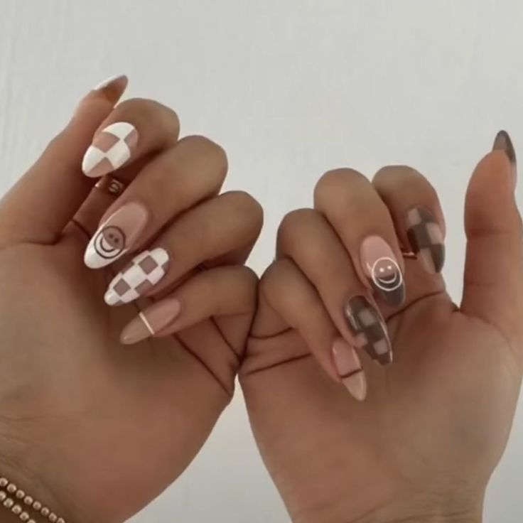 Playful and Trendy Nail Design: A Chic Mix of Colors and Patterns with Neutral Tones and Cheerful Smiley Faces.