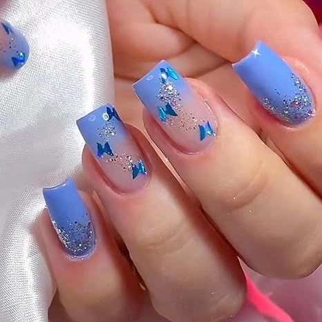 Whimsical Blue Nail Design: Glossy Gradient with Glitter and Bow Embellishments.