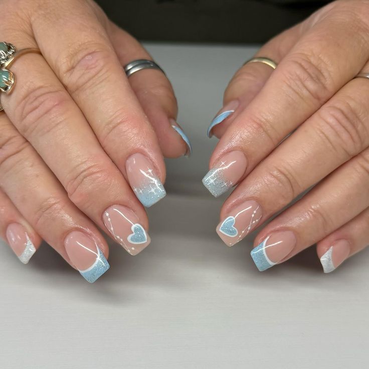 Charming Delicate Nail Design: Soft Pink Base, Elegant Blue Tips, and Sparkling Heart Accents.