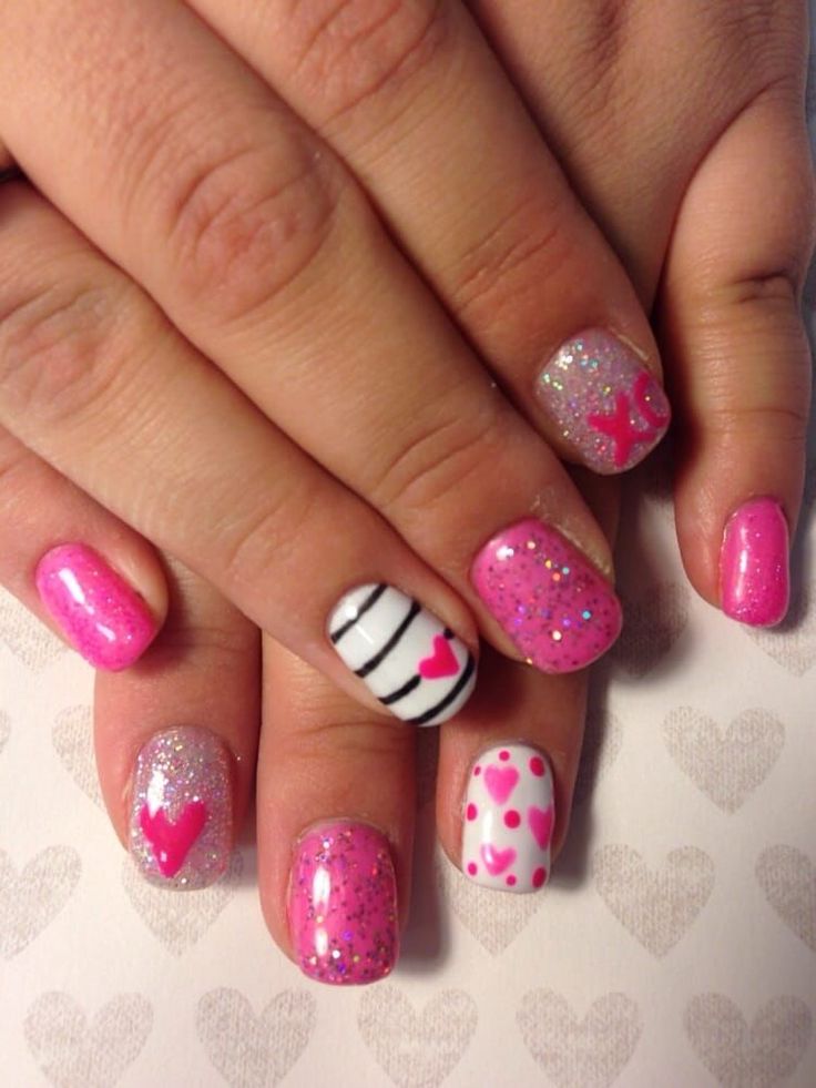 Playful Vibrant Pink Nail Design with Textures, Glitter, and Heart Motifs.