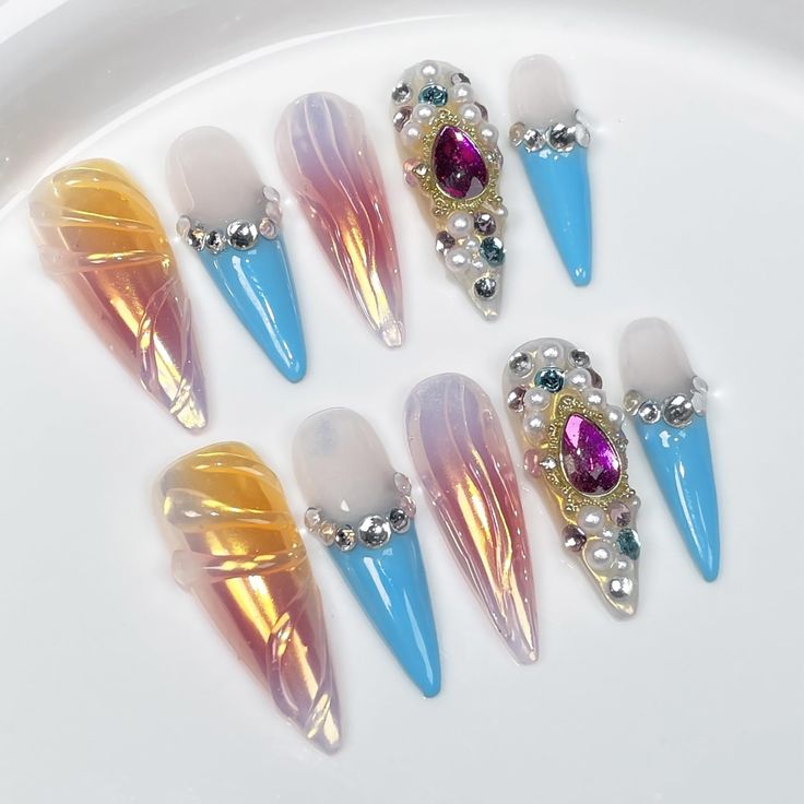 Vibrant Elongated Stiletto Nail Design with Intricate Details and Glamorous Accents.