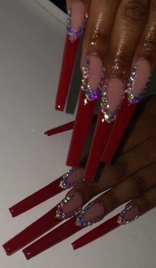 Vibrant Red Stiletto Nails with Rhinestone-Embellished Nude Base: A Stunning Manicure Statement.