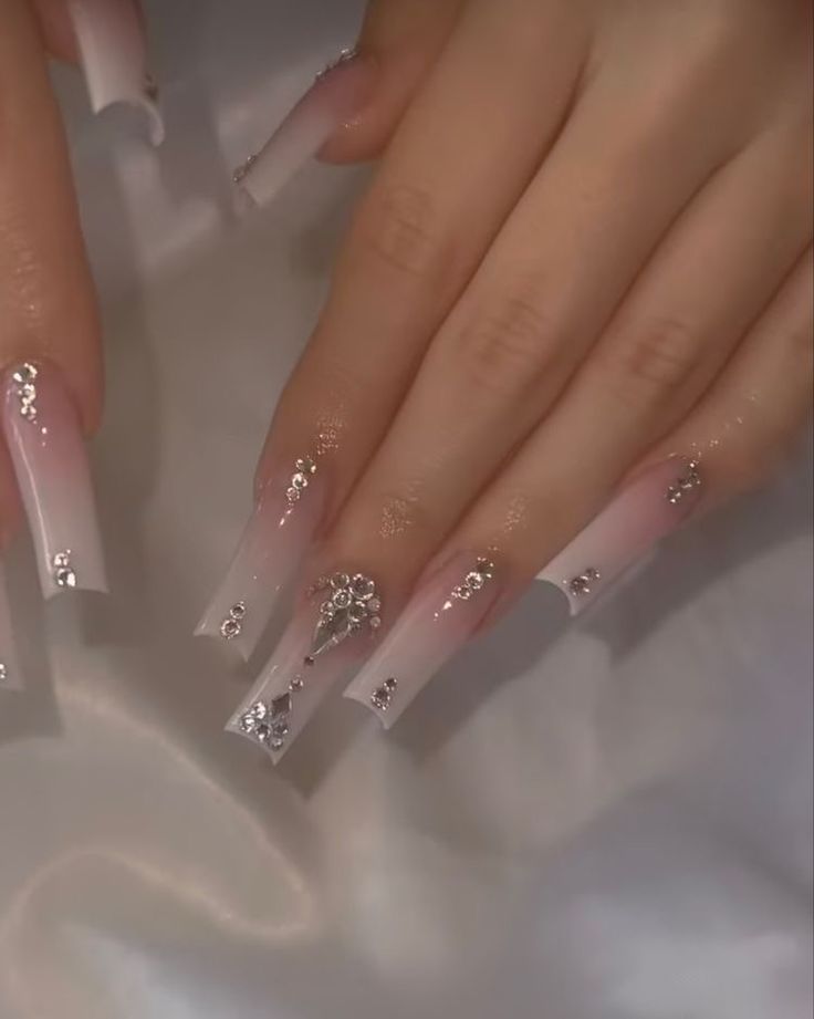 Elegant Ombre Nails: A Sophisticated Blend of Soft Pink, Clear Tips, and Sparkling Rhinestones.