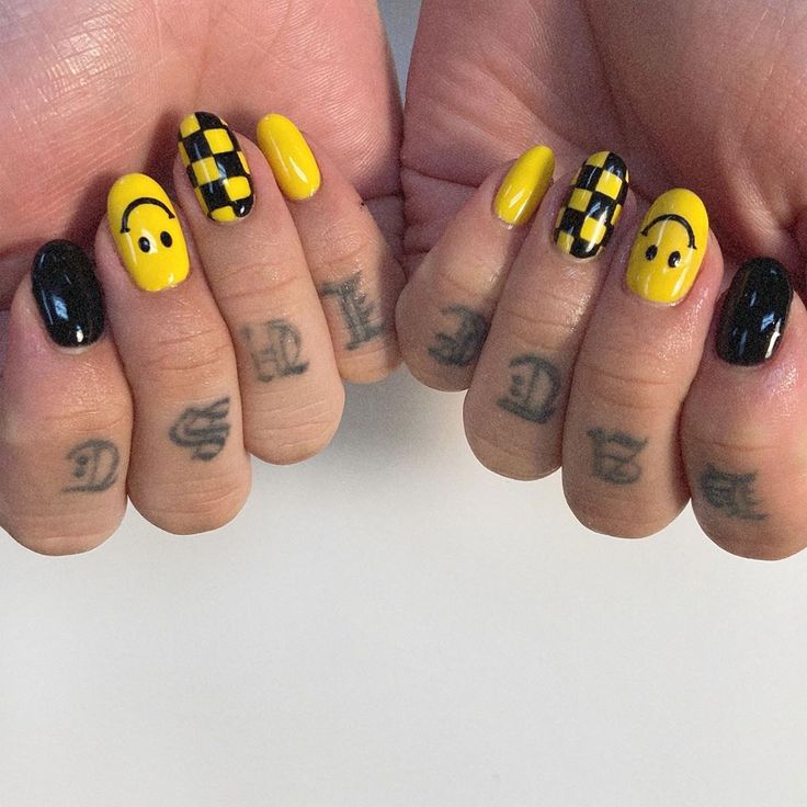 Bold Yellow and Black Nail Design with Checkerboard Patterns and Smiley Faces for a Playful Aesthetic.