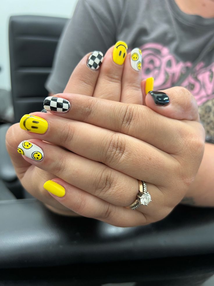 Cheerful Nail Art: Vibrant Yellow Base with Smiley Faces and Checkered Accents