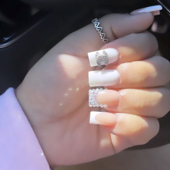 Elegant Chic Nail Design: Classic White Tips with Sparkling Glitter Accents.