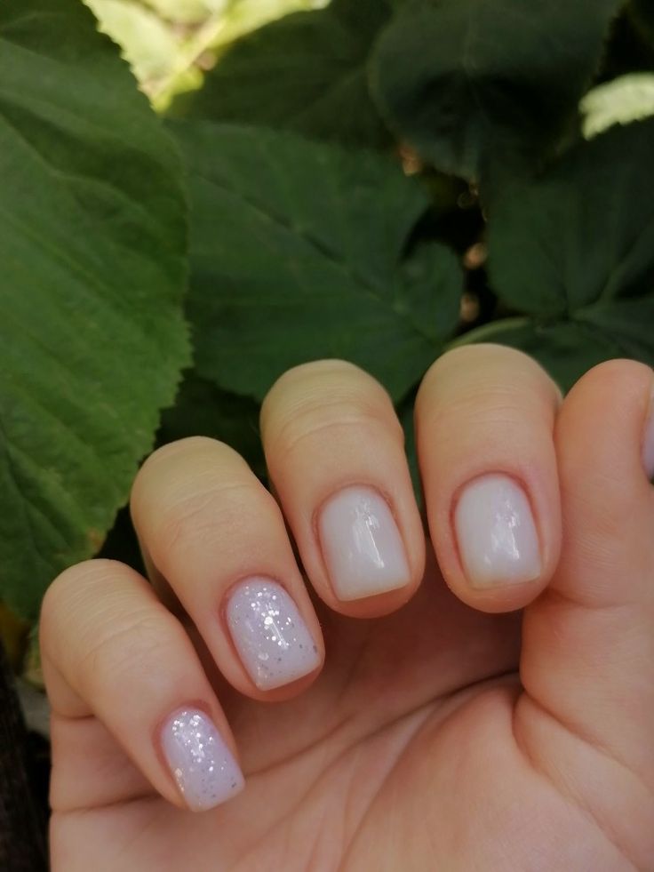 Elegant Soft White Nail Design with Subtle Glitter Accents