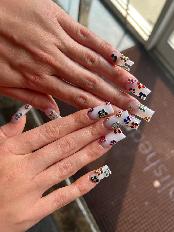 Glamorous Pastel and White Nail Design Embellished with Colorful Gems.