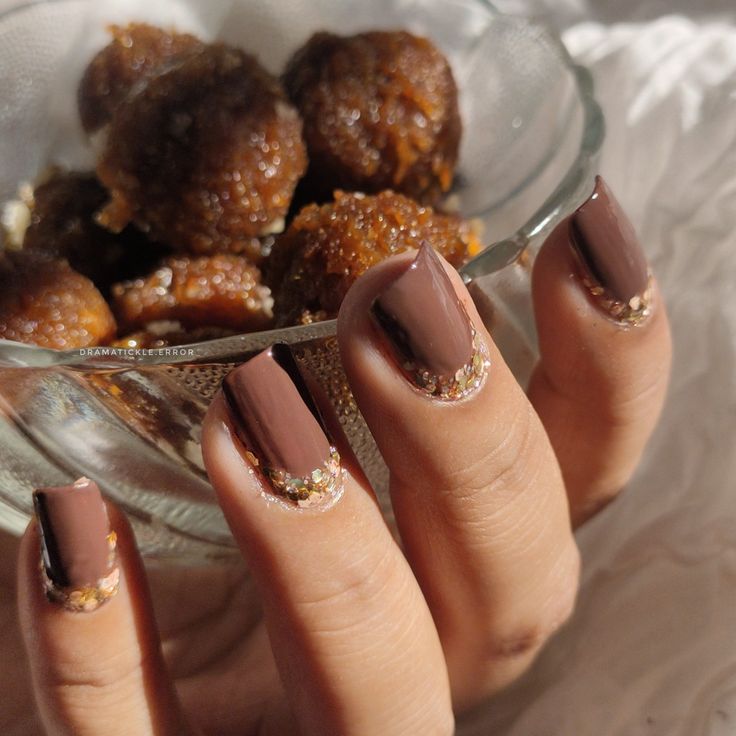 Sophisticated Elegance: Rich Brown Polish with Sparkling Glitter Accents for a Glamorous Manicure.