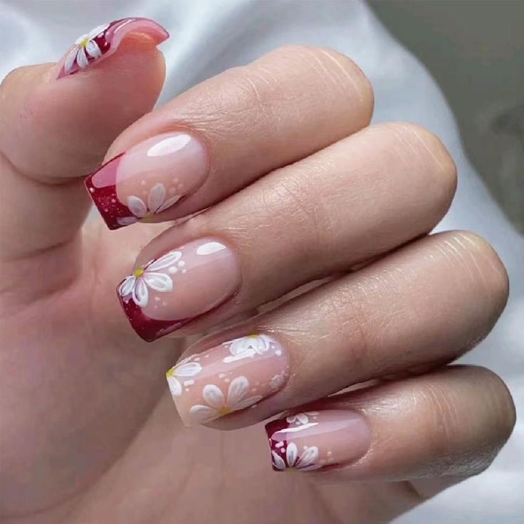 Chic Ombre Nail Design with Floral Accents in Nude and Vibrant Red.