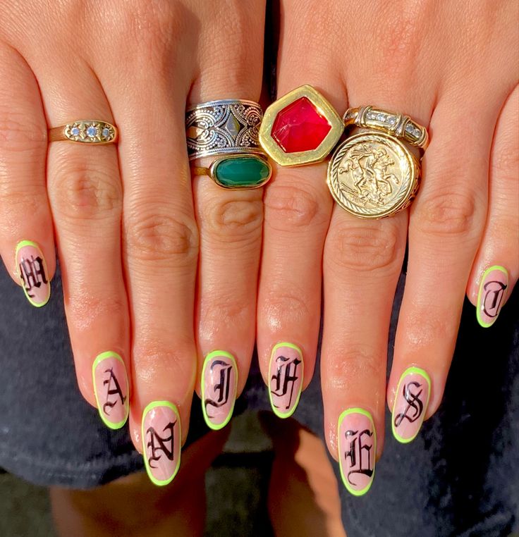 Bold Almond-Shaped Nail Art: Soft Pink Base, Neon Green Tips, and Striking Black Detailing.