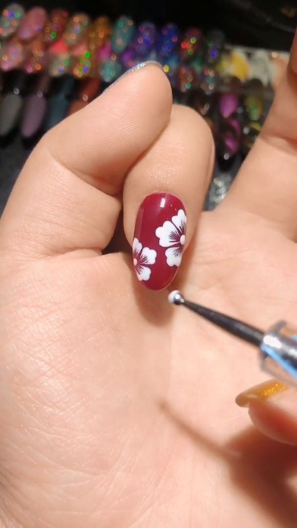 Striking Burgundy Floral Nail Design: Elegant Artistry with a Bold Touch.