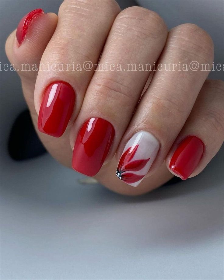 Sophisticated Red Nail Design with Artistic Floral Accent.