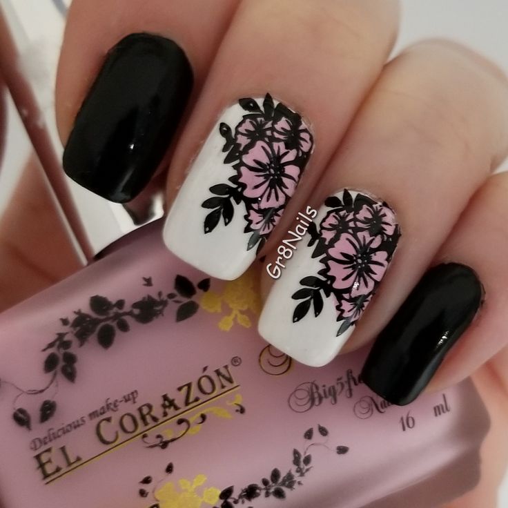 Elegant Floral Nail Art: Striking Black and White Contrast with Pink Accents.