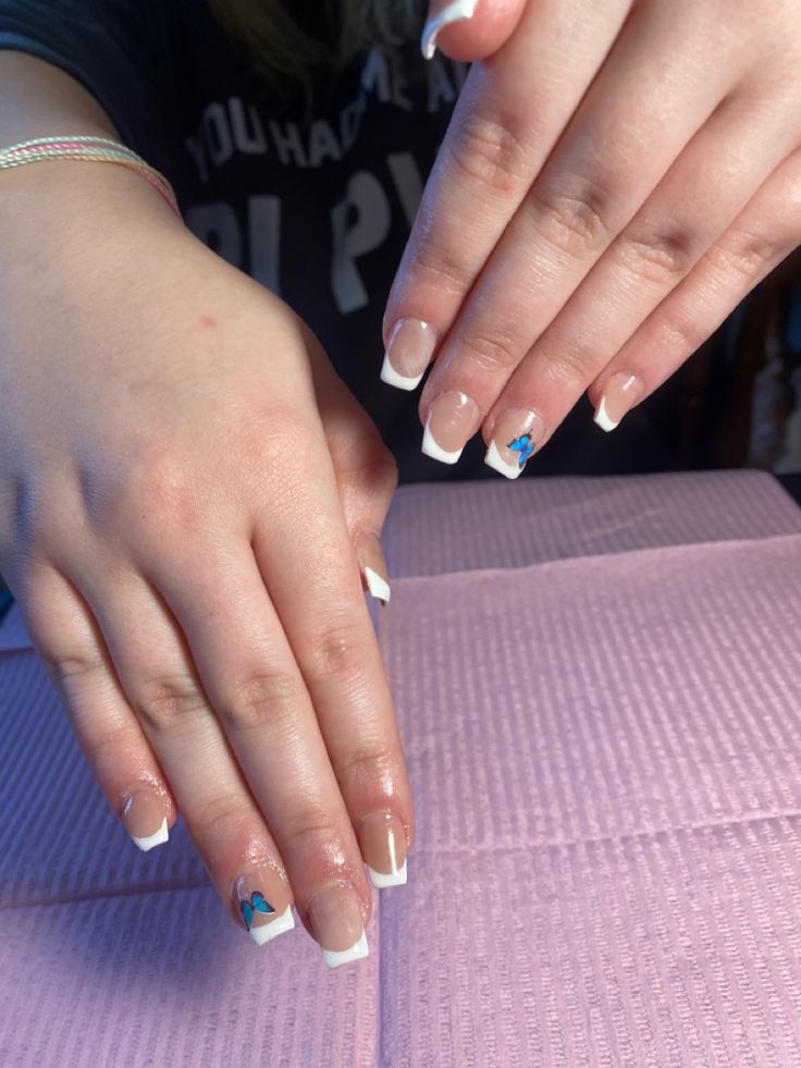 Artistic Elegant French Manicure: Sophisticated Neutral Base with Unique Blue Accents.